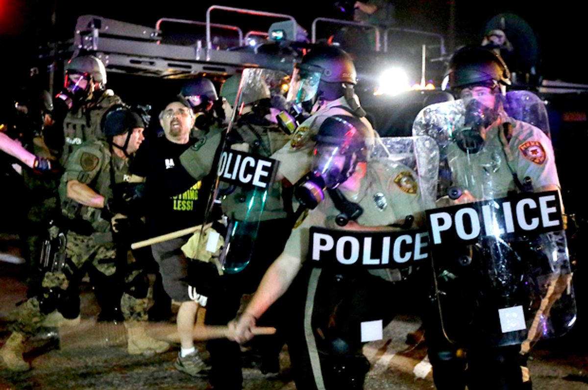A man is detained after a standoff between protesters and police Monday, Aug. 18, 2014, in Ferguson, Mo.           (AP/Charlie Riedel)