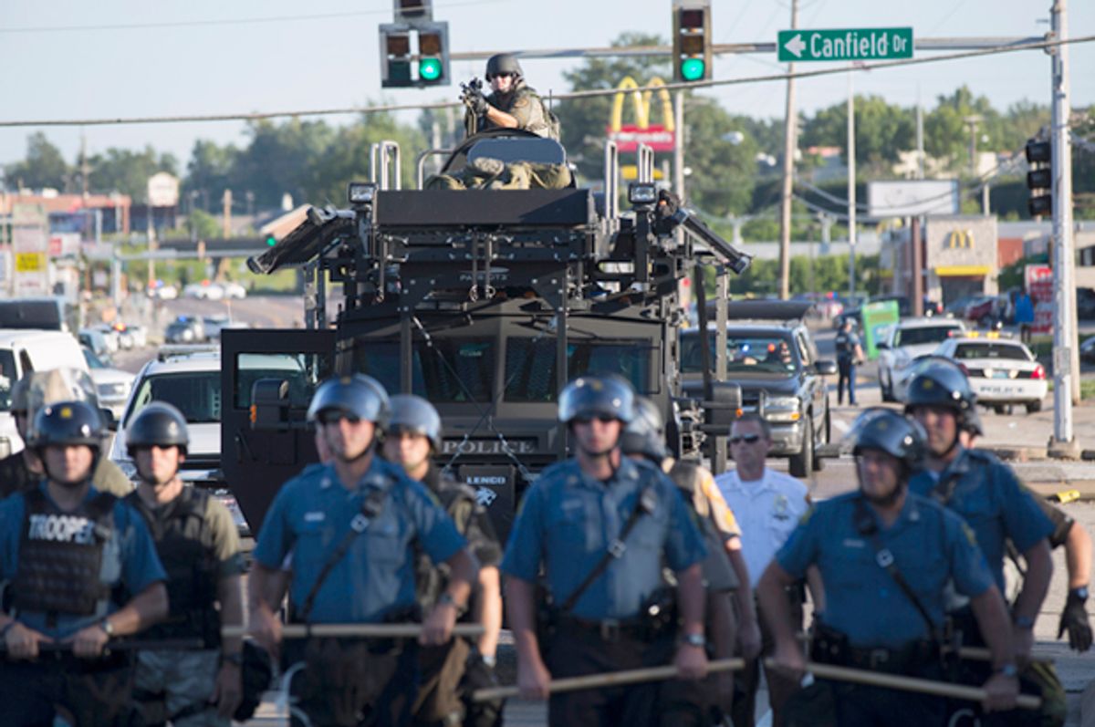 Riot police stand guard as demonstrators protest the shooting death of teenager Michael Brown in Ferguson, Missouri August 13, 2014.                   (Reuters/Mario Anzuoni)
