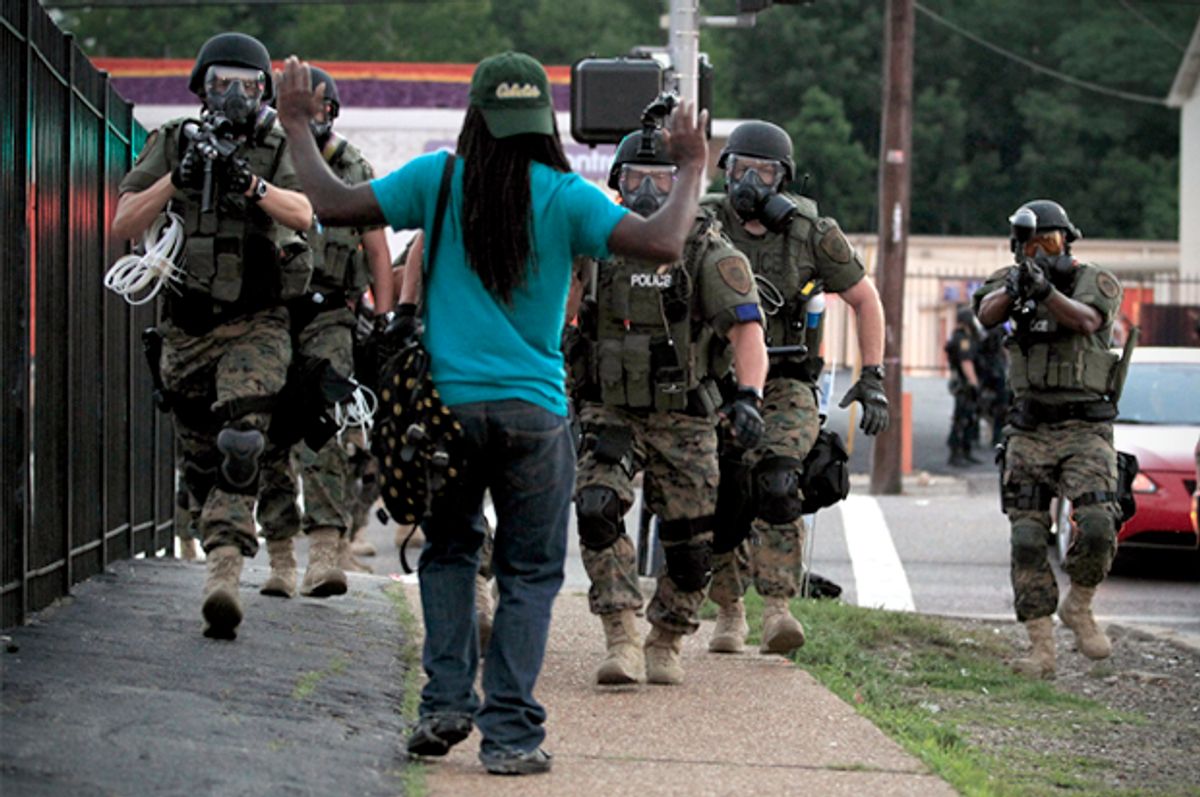 Police wearing riot gear walk toward a man with his hands raised Monday, Aug. 11, 2014, in Ferguson, Mo.                        (AP/Jeff Roberson)