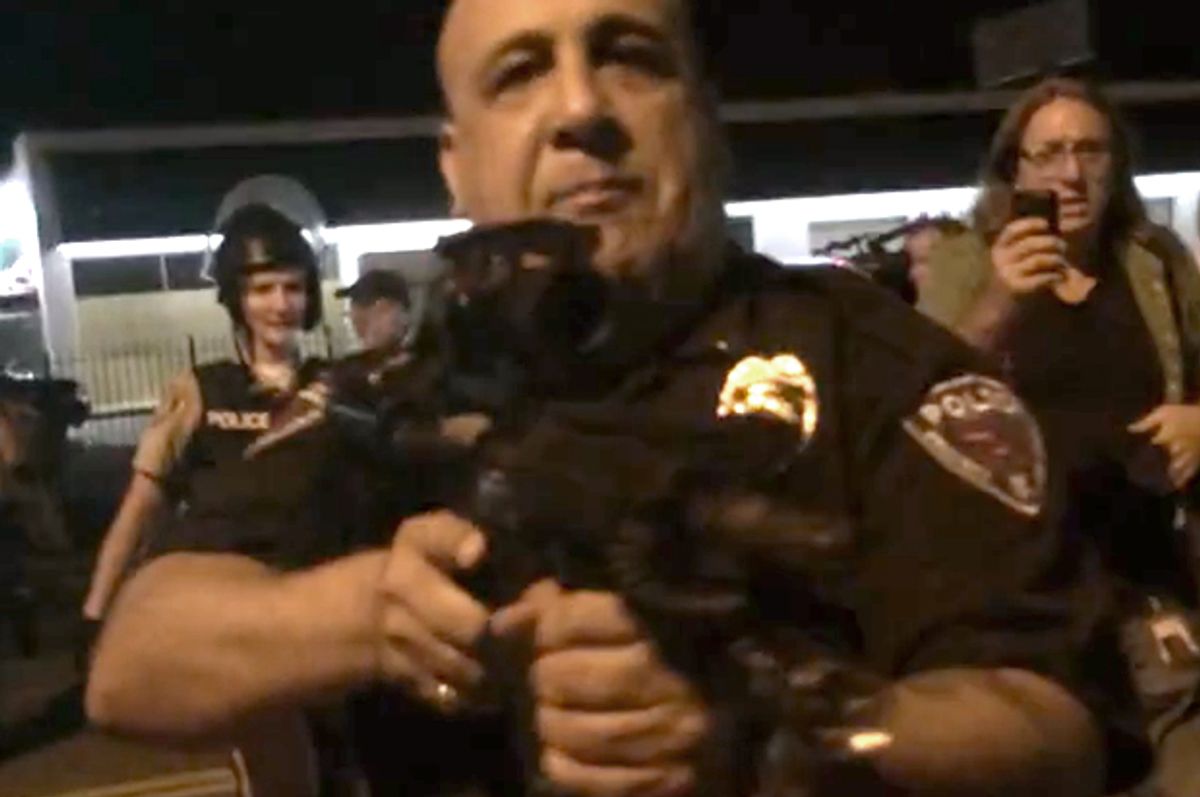 An officer points his rifle at the crowd in Ferguson.        (YouTube/Caleb-Michael Files)