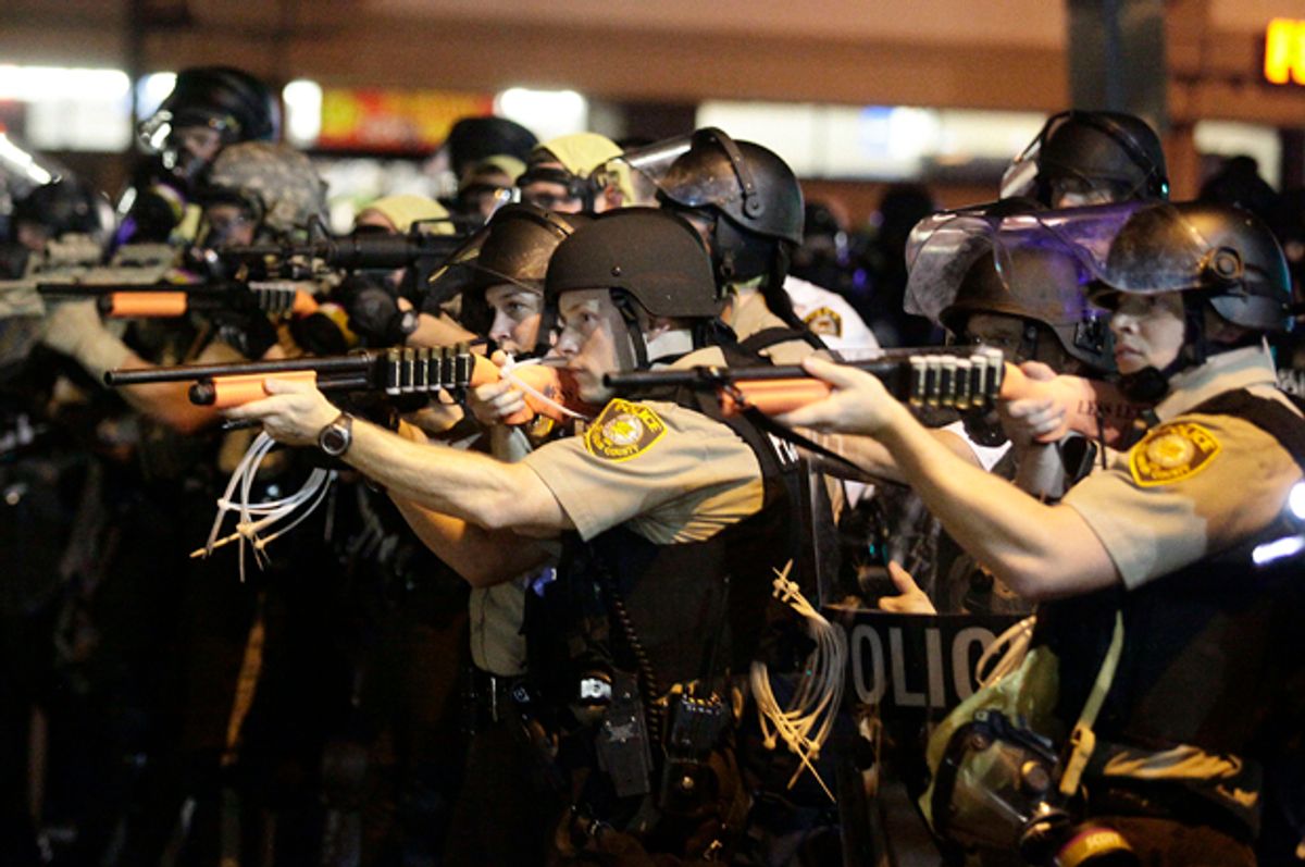 Police officers point their weapons at demonstrators in Ferguson, Missouri, August 18, 2014.                                             (Reuters/Joshua Lott)