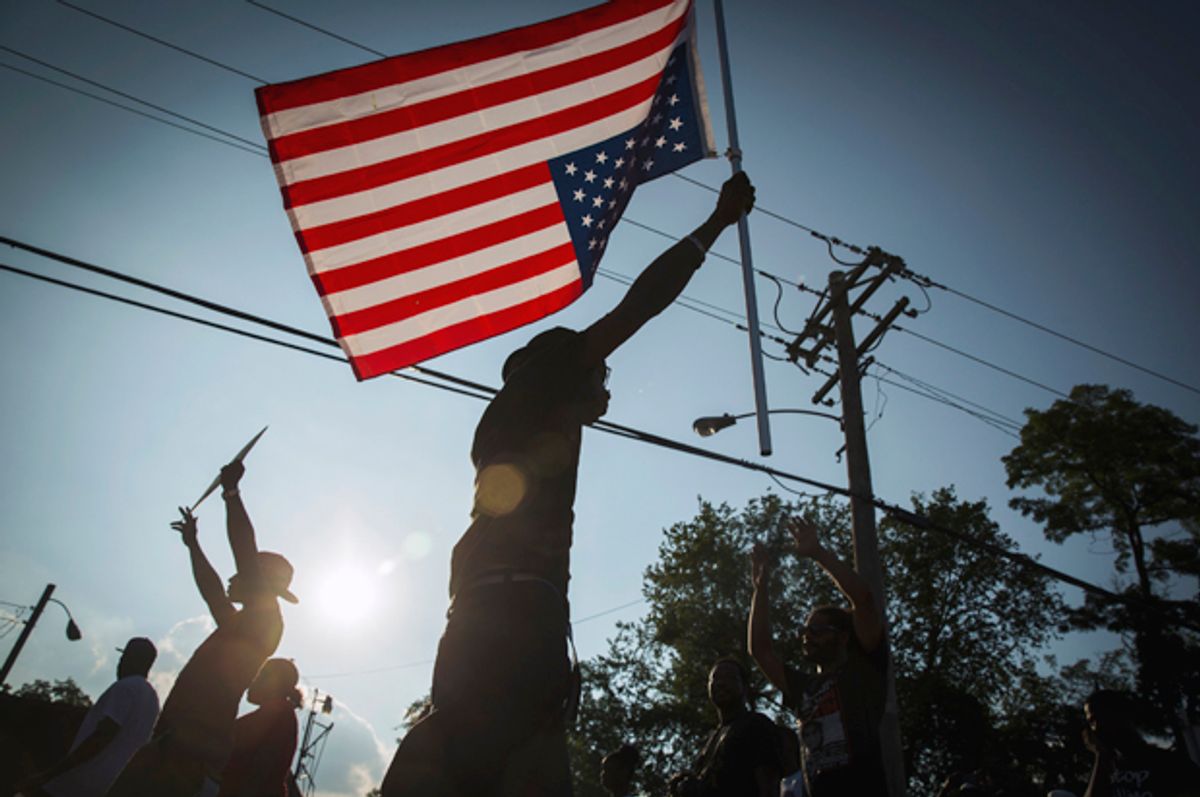 Demonstrators march down West Florissant with a U.S. flag during a peaceful march in Ferguson, Missouri August 18, 2014.           (Reuters/Lucas Jackson)