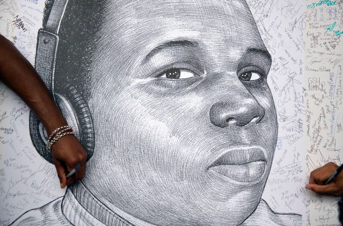 In a Monday, Aug. 18, 2014 file photo, protestors autograph a sketch of Michael Brown during a protest, in Atlanta. Michael Brown Jr. was on the verge of starting college, eager to launch himself into the adult world. Instead, on Monday hell be mourned at his funeral, more than two weeks after his fatal shooting by a white police officer.    (AP/David Goldman)