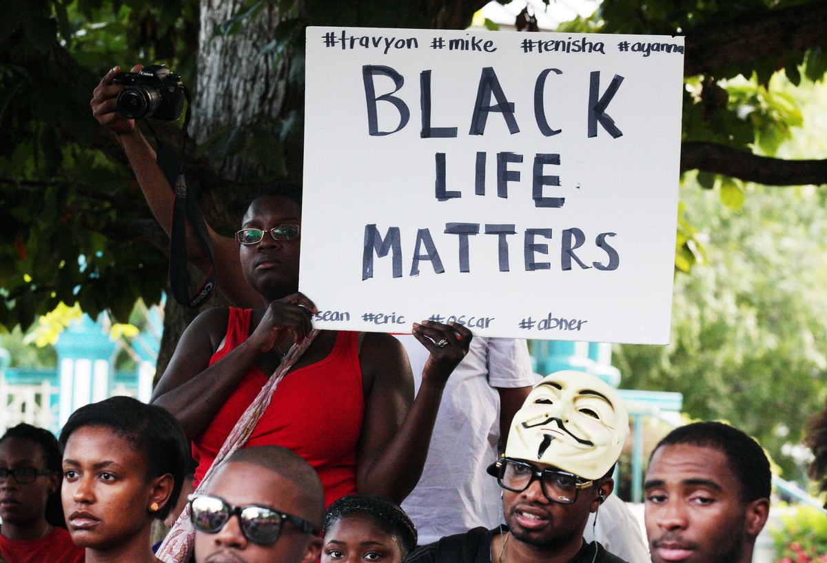 People in a crowd hold signs and listen to speakers at a demonstration on Thursday, Aug. 14, 2014, in Decatur, Georgia, in the town square. The demonstration of more than 200 people was held in response to the shooting death of Michael Brown and following unrest in Ferguson, Missouri. (AP Photo/ Ron Harris)      (Ron Harris)