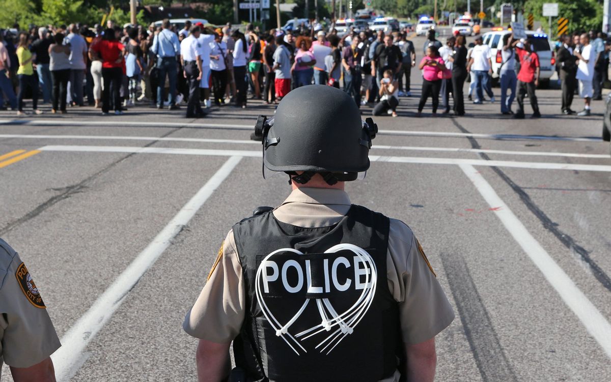 A line of police waits for demonstrators in Ferguson, Mo., Aug. 13, 2014.    (AP/J. B. Forbes)