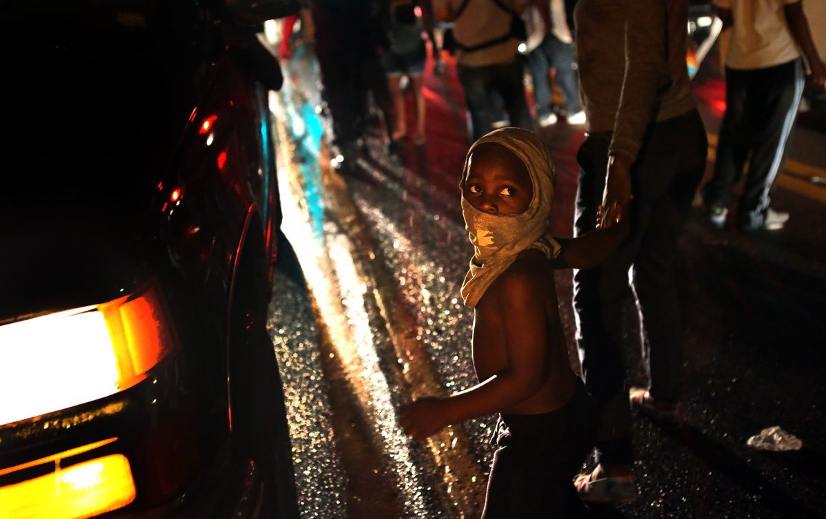 Isaiah King Ivy, 3, makes his shirt a mask as he participates in demonstrations with his north St. Louis County family on West Florissant Avenue in Ferguson on Friday, Aug. 15, 2014.  (AP Photo/St. Louis Post-Dispatch, Robert Cohen)          (AP)