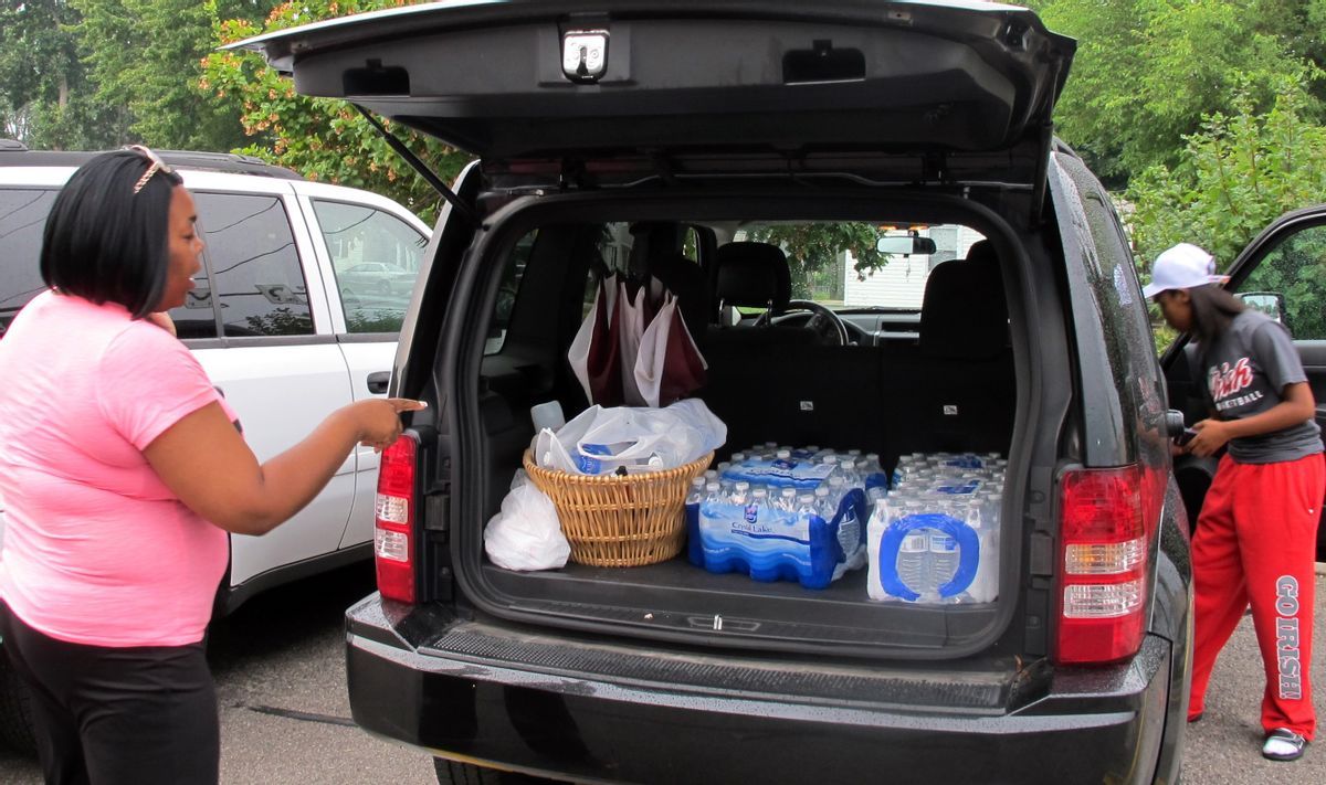 Aundrea Simmons stands next to her minivan with cases of bottled water she bought after Toledo warned residents not to use its water, Saturday, Aug. 2, 2014  in Toledo, Ohio. About 400,000 people in and around Ohio's fourth-largest city were warned not to drink or use its water after tests revealed the presence of a toxin possibly from algae on Lake Erie. (AP Photo John Seewer)