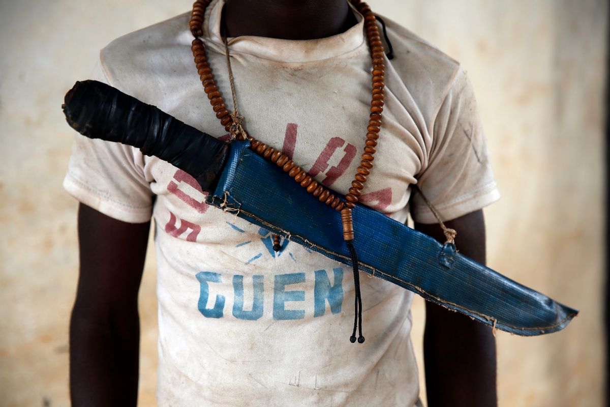 In this April 15, 2014 photo, an Anti-Balaka Christian fighter stands on the front of a looted Muslim store in Guen, some 250 kilometers north of Bangui, Central African Republic. As U.N. peacekeepers prepare to go into the Central African Republic to take over a regional mission, the death toll since fighting between Muslims and Christians started in December underscores how the aid is coming too late for thousands of victims. (AP Photo/Jerome Delay) (AP)