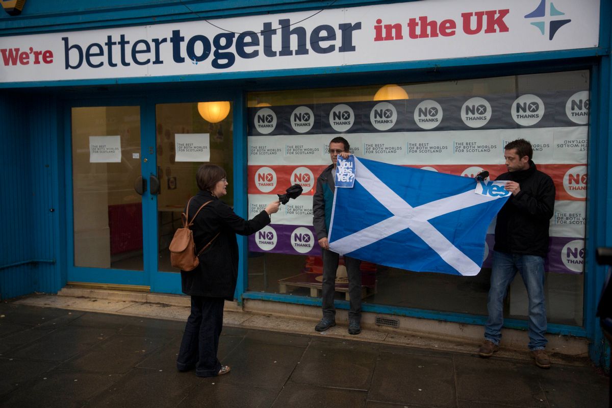 A passerby argues with two Scottish independence referendum 'Yes' supporters holding a Scottish Saltire flag outside the "Better Together" No campaign offices in Edinburgh, Scotland, Monday, Sept. 15, 2014.  If Scottish voters this week say Yes to independence, not only will they tear up the map of Great Britain, they'll shake the twin pillars of Western Europe's postwar prosperity and security  the European Union and the U.S.-led NATO defense alliance.  () (AP Photo/Matt Dunham)