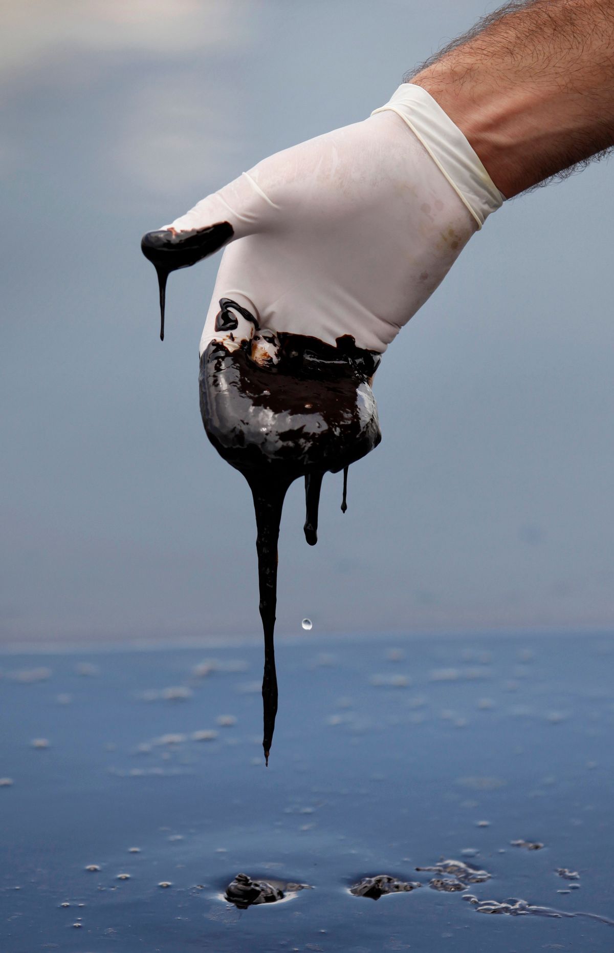 A member of Louisiana Gov. Bobby Jindal's staff reaches into thick oil in the Northern regions of Barataria Bay in Plaquemines Parish, La., Tuesday, June 15, 2010. (AP Photo/Gerald Herbert)  (Gerald Herbert)