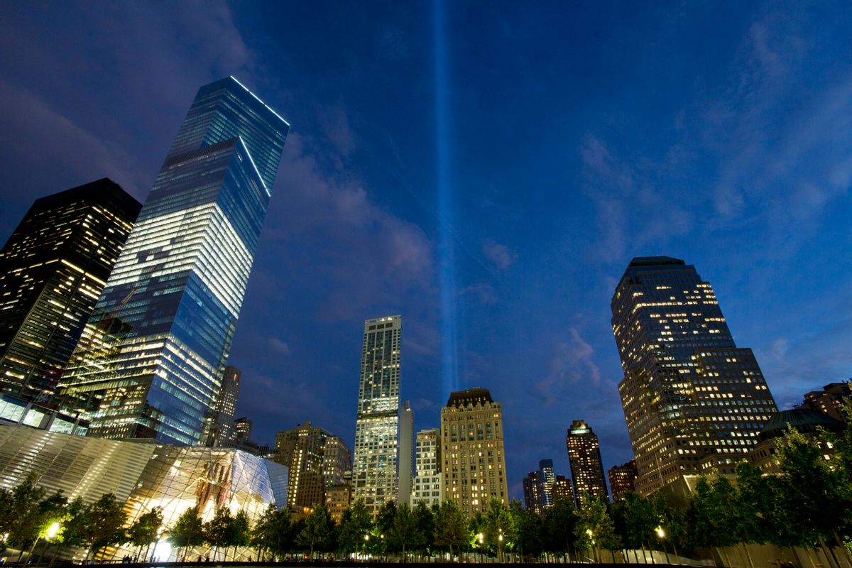 In this Monday, Sept. 8, 2014 photo, the Tribute in Light rises behind buildings adjacent to the World Trade Center in New York. The art installation consists of 88 searchlights aiming skyward in two columns, in memory of the former twin towers. Four World Trade Center is at left.  (AP Photo/Mark Lennihan) (AP)