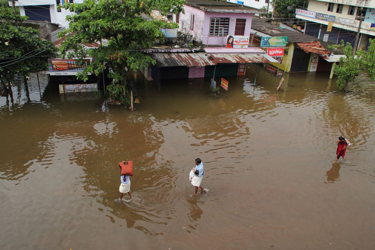 Unidentified people walk on the flood water on June 26,2013 in Kuttanad, India. (AJP/Shutterstock)