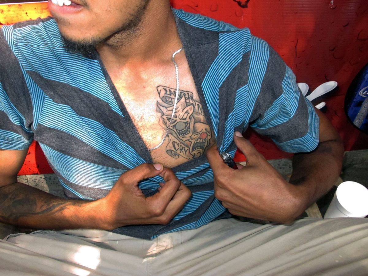 In this Sept. 5, 2014 photo, a reputed member of the Los Solidos street gang shows his tattoo to police in Hartford, Conn.  ((AP Photo/Dave Collins))