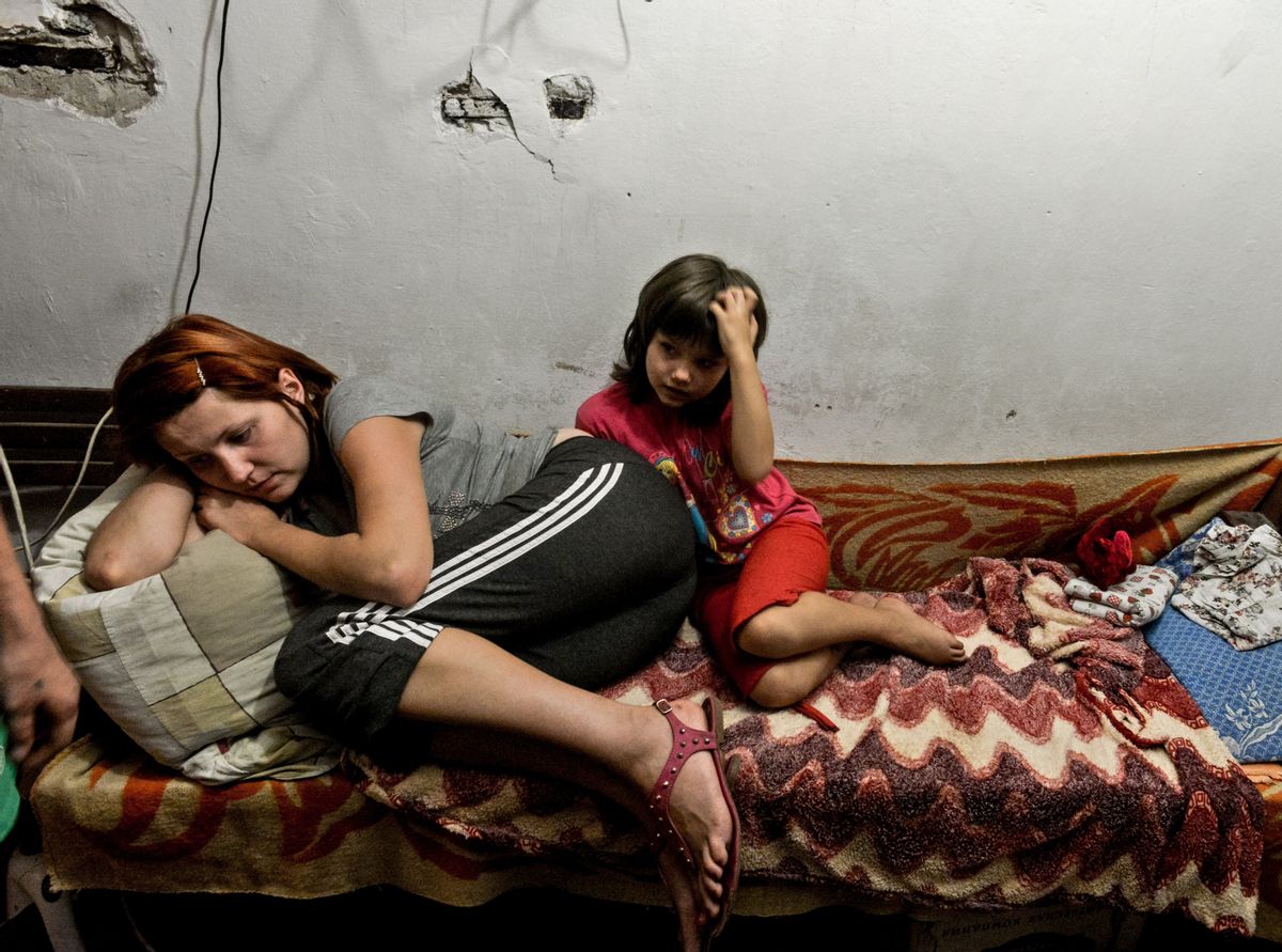 A mother and child lie on the bed in the bomb shelter in Petrovskiy district, in Donetsk, eastern Ukraine, Monday Sept. 1, 2014. The Petrovskiy district of Donetsk is currently a frontline and one of the districts which has suffered the most from the artillery fights between Ukrainian army and Pro-Pussian rebels. (AP Photo/Mstislav Chernov) (AP)