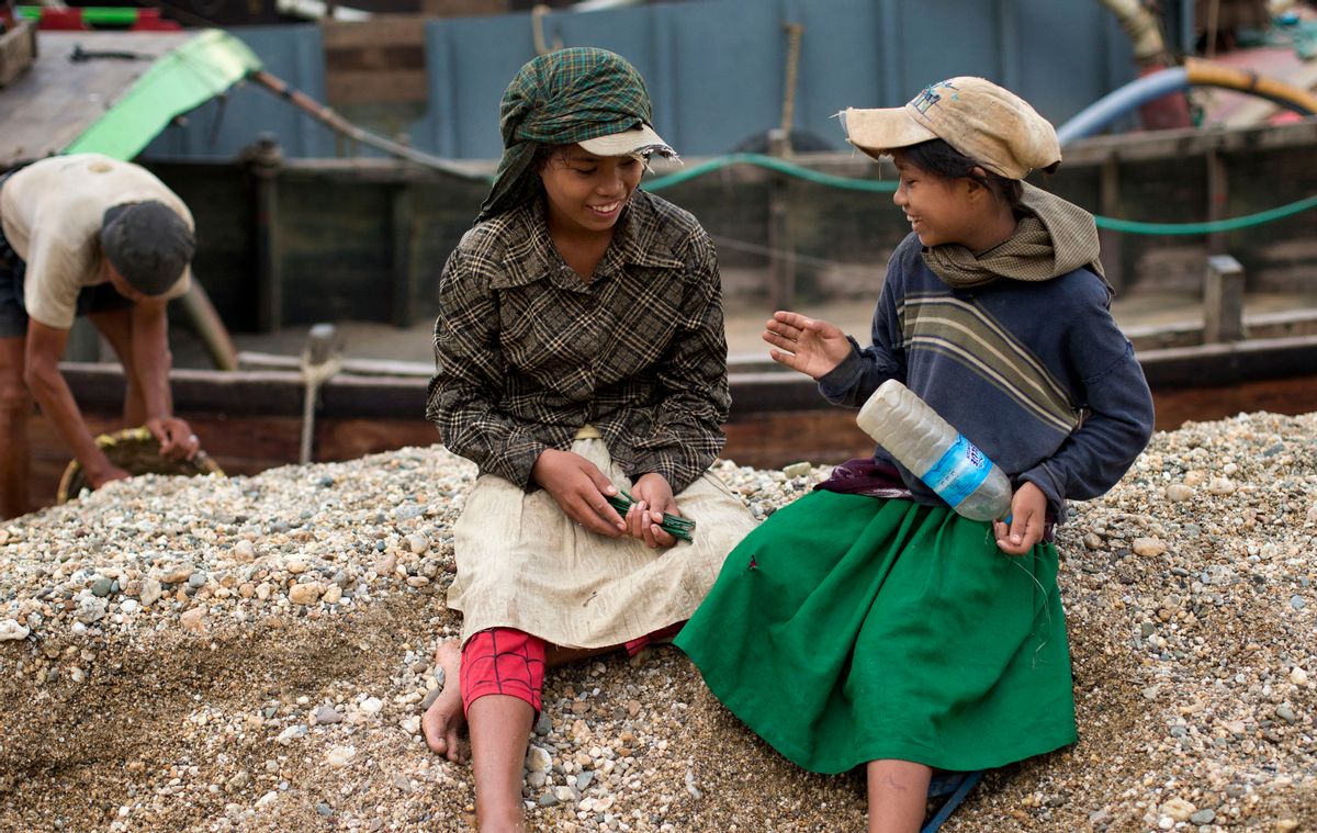 In this Nov. 22 2012 photo, Po Po Aung, left and Cho Cho Aung right count sticks-that reflects the tally of baskets of gravel they hulled in a riverside barge in Yangon, Myanmar. The sisters haul gravel for less than 4 cents for each 20 kilogram (44 pound) basket, earning money to pay for school fees. From India to Indonesia, Myanmar and the Philippines, overcrowded cities have become studies in extremes of deprivation and wealth. (AP Photo/Gemunu Amarasinghe) (AP)