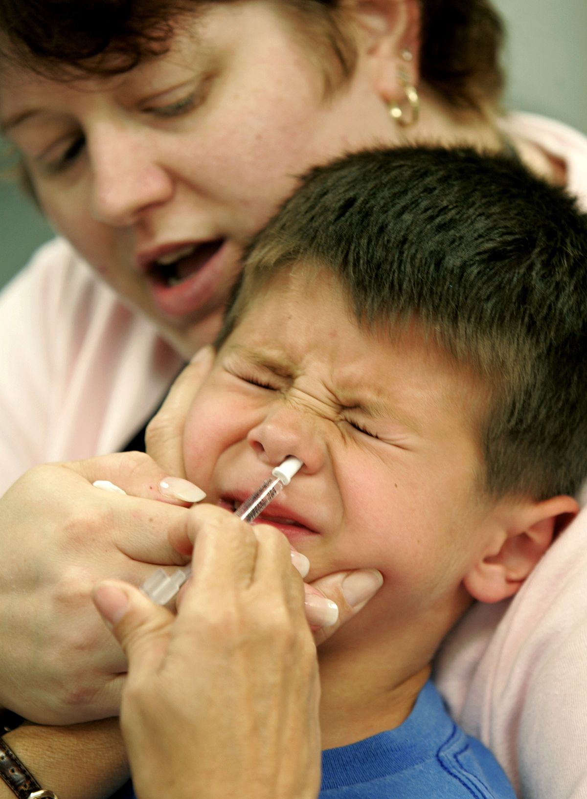 Eric Krex, 6, reacts as he is held by his mother, Margaret, while a nurse gives him a FluMist influenza vaccination  (Photo/Chris Gardner)