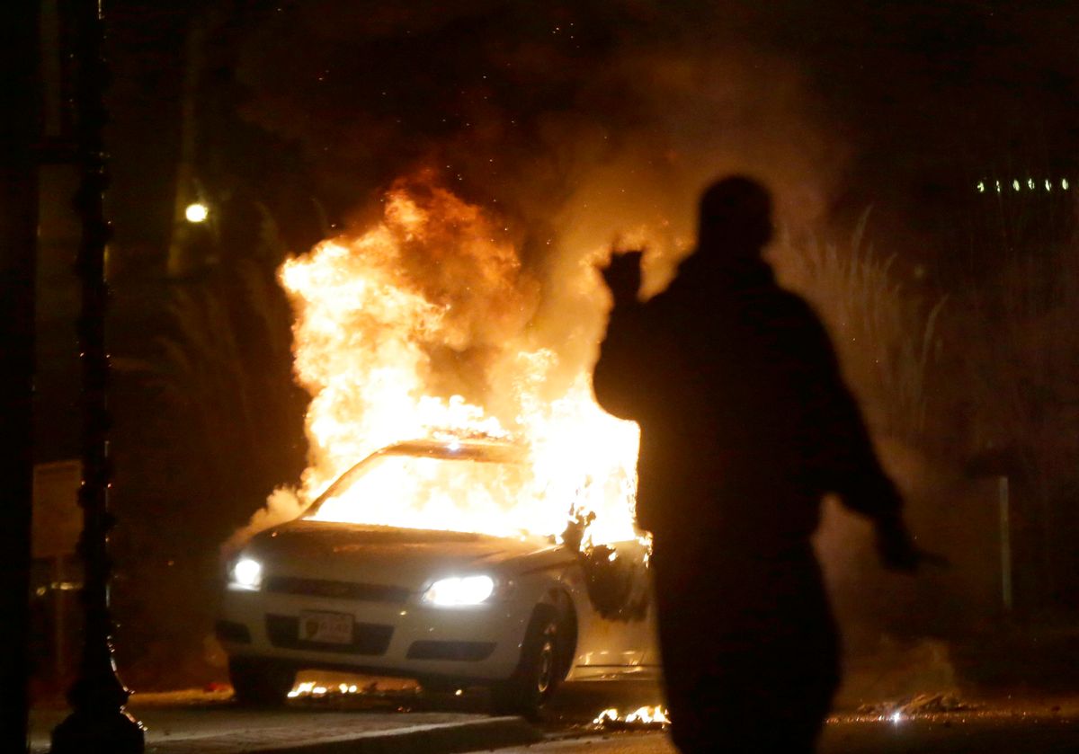 A police car is set on fire after a group of protesters vandalize the vehicle after the announcement of the grand jury decision Monday, Nov. 24, 2014, in Ferguson, Mo. A grand jury has decided not to indict Ferguson police officer Darren Wilson in the death of Michael Brown, the unarmed, black 18-year-old whose fatal shooting sparked sometimes violent protests. (AP Photo/Charlie Riedel)     (AP)