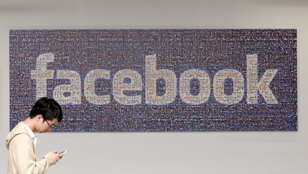 A man walks past a sign in an office on the Facebook campus in Menlo Park, Calif.  (AP/Jeff Chiu)