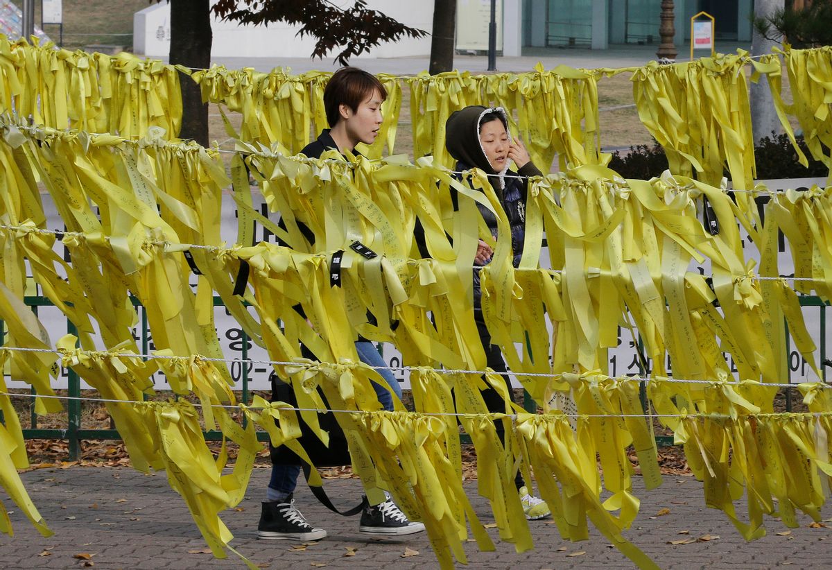 People pass by yellow ribbons with messages for missing passengers and victims aboard sunken ferry Sewol near a group memorial altar in Ansan, South Korea, Tuesday, Nov. 11, 2014. The captain of a ferry that sank earlier this year, leaving more than 300 people dead and shocking South Korea, was given a 36-year prison sentence Tuesday for negligence and abandoning his passengers.(AP Photo/Ahn Young-joon) (AP)