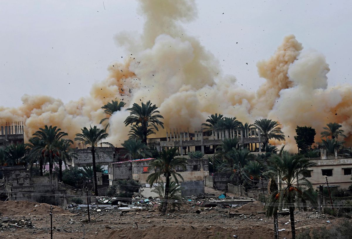 In this Tuesday, Nov. 4, 2014 photo, Smoke rises from explosions demolishing houses on the Egyptian side of the border town of Rafah as seen from the Palestinian side of Rafah in the southern Gaza Strip. With dynamite and heavy machinery, Egypt's army has been demolishing homes along its border with the Gaza Strip, after the military ordered residents out last week to make way for a planned buffer zone meant to stop militants and smugglers. (AP Photo/Adel Hana) (AP)