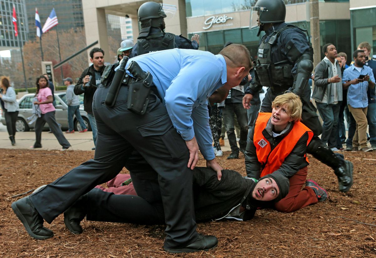 A clergy member assists a protester as he is taken to the ground on Sunday, Nov. 30, 2014, at Kiener Plaza in St. Louis. Protesters and police clashed following an NFL football game between the St. Louis Rams and the Oakland Raiders as protests continued following a grand jury's decision not to indict a Ferguson police officer in the shooting death of Michael Brown. (AP Photo/St. Louis Post-Dispatch, Laurie Skrivan)  EDWARDSVILLE INTELLIGENCER OUT; THE ALTON TELEGRAPH OUT   (AP)