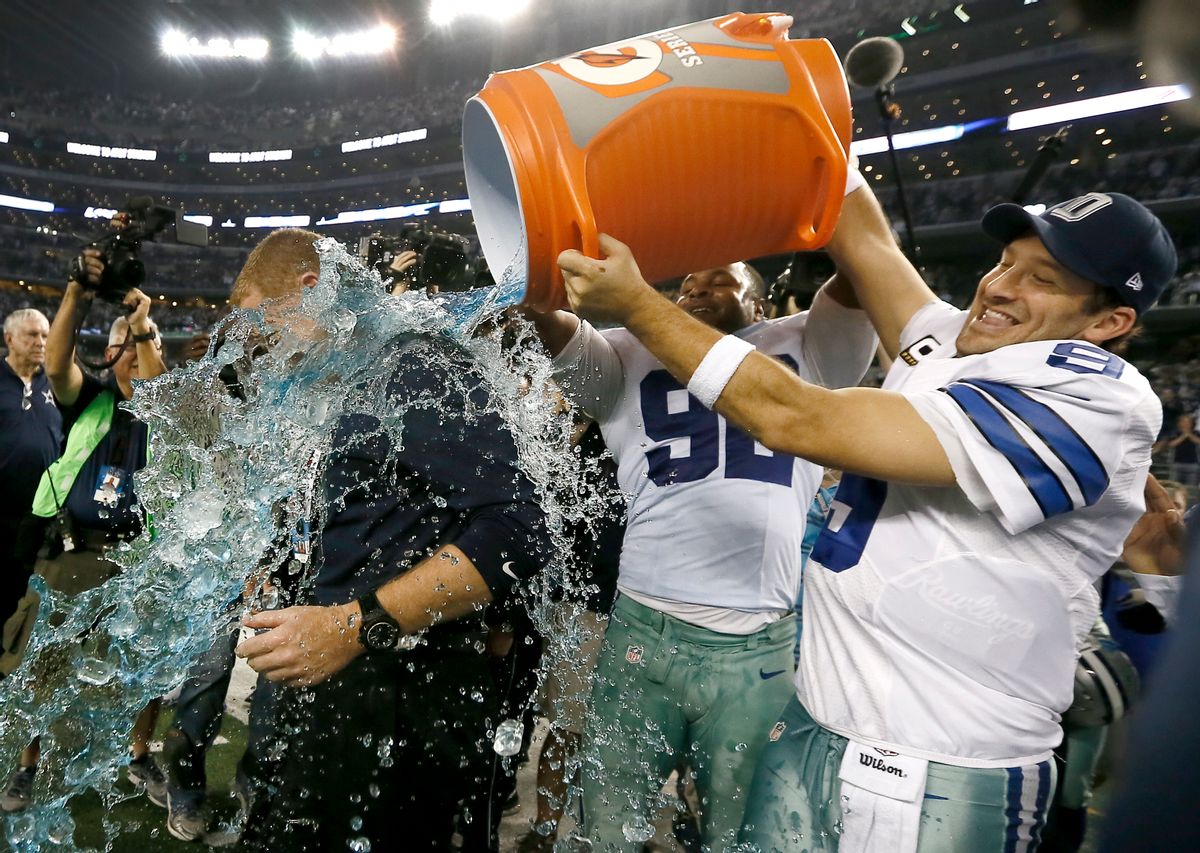 Dallas Cowboys head coach Jason Garrett is doused by Dallas Cowboys' Jeremy Mincey, center and quarterback Tony Romo, right, after their 42-7 win over the Indianapolis Colts in an NFL football game, Sunday, Dec. 21, 2014, in Arlington, Texas. The Cowboys won 42-7. (AP Photo/Brandon Wade) (AP)