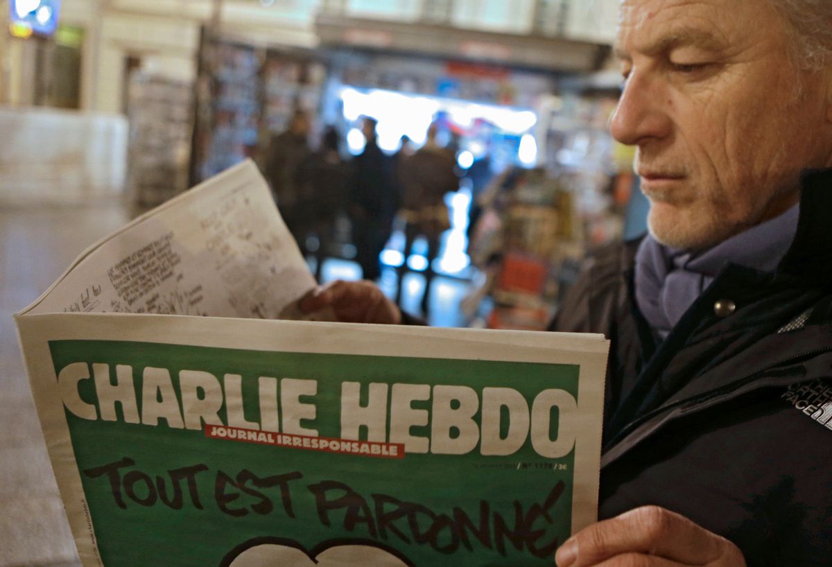 Jean Paul Bierlein reads the new Charlie Hebdo newspapers next a newsstand in Nice, southeastern France, Wednesday, Jan. 14, 2015. (AP Photo/ Lionel Cironneau)  (Lionel Cironneau)
