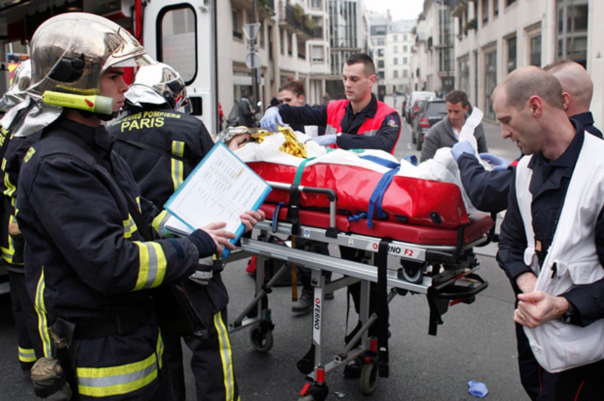 An injured person is carried into an ambulance at the French satirical newspaper Charlie Hebdo's office, in Paris, Jan. 7, 2015.                 (AP/Thibault Camus)