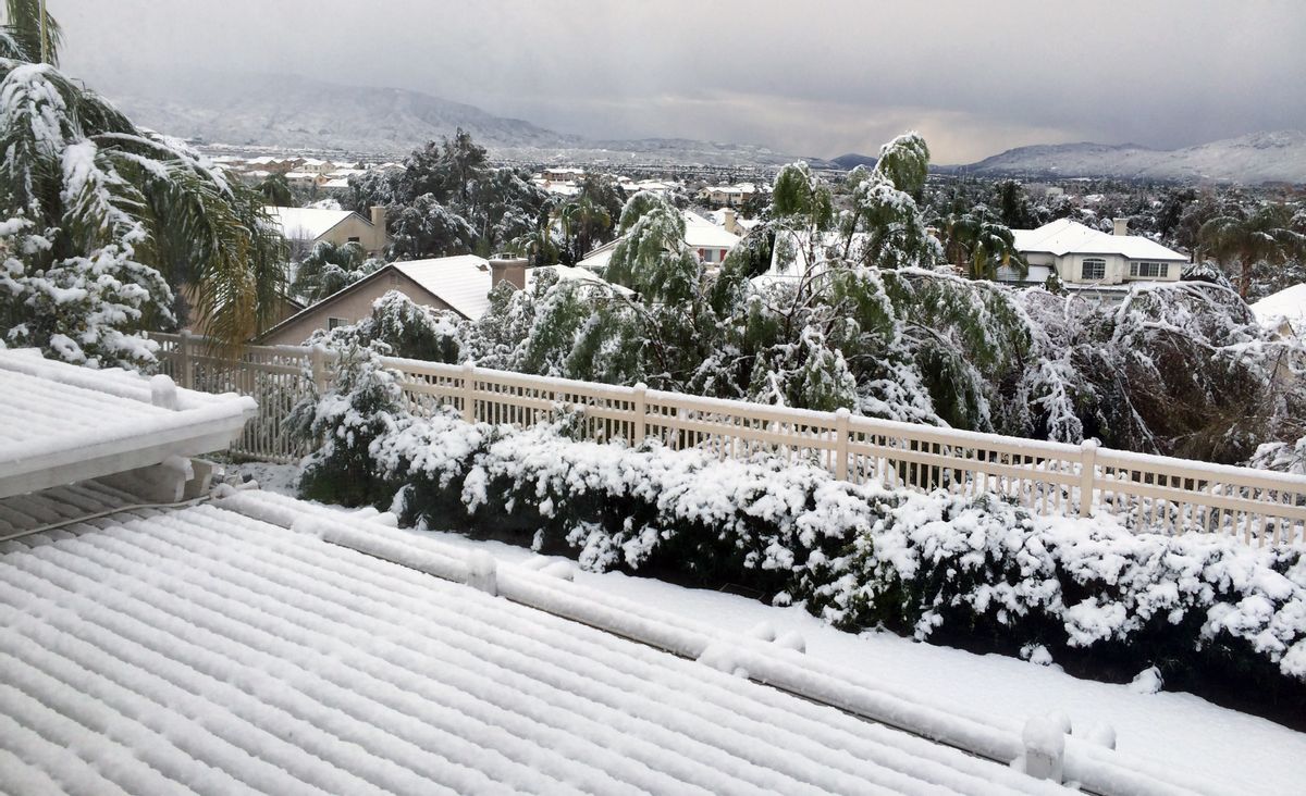 This photo provided by Elsa Metzger shows snowfall over a Southern California neighborhood in Temecula, Calif., on Wednesday, Dec. 31, 2014. A blustery winter storm dropped snow on very low elevations across inland Southern California early Wednesday after stranding dozens of motorists on mountain highways. (AP Photo/Elsa Metzger) (AP)