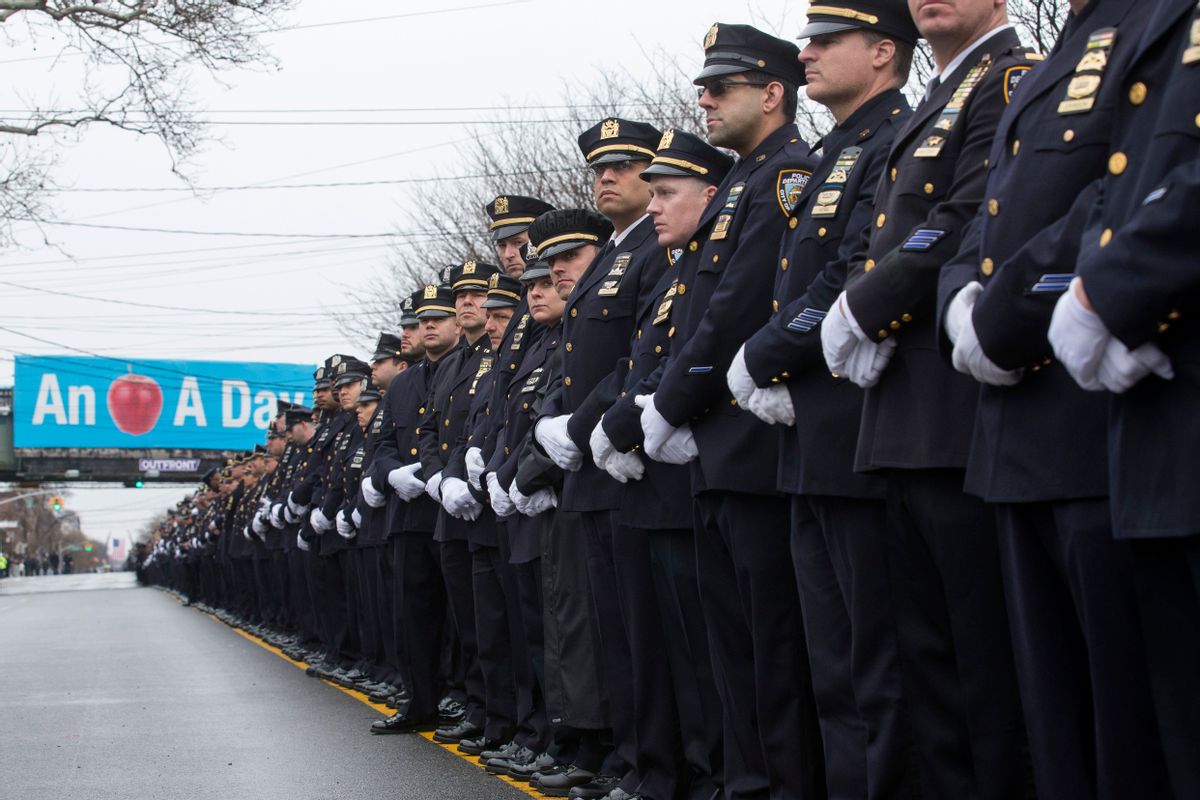 Police officers stand along the procession route during the funeral of New York Police Department Officer Wenjian Liu, Sunday, Jan. 4, 2015, in the Brooklyn borough of New York. Liu and his partner, officer Rafael Ramos, were killed Dec. 20 as they sat in their patrol car on a Brooklyn street. The shooter, Ismaaiyl Brinsley, later killed himself. (AP/John Minchillo)