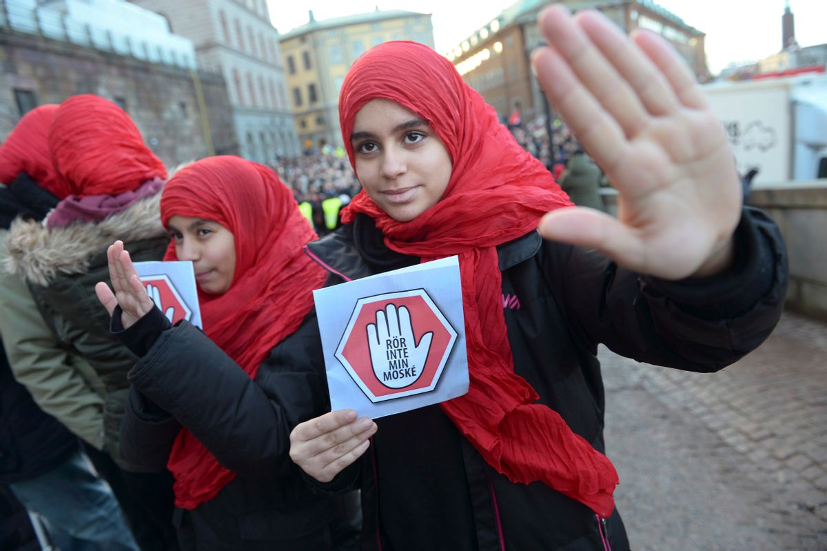 Two young girls carrying leaflets saying "don't touch my mosque" participate in a demonstration at the  parliament in Stockholm on Friday  Jan. 2, 2015. Three mosques have suffered arson attacks in Sweden since Christmas Day. (AP Photo/Fredrik Sandberg) SWEDEN OUT (AP)