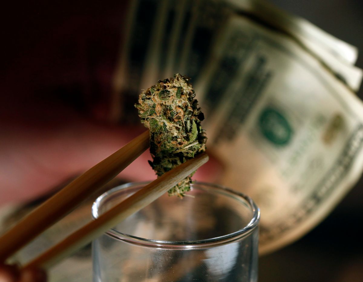 In this Sept. 18, 2012, file photo a caregiver picks out a marijuana bud for a patient at a marijuana dispensary in Denver.    (AP/Ed Andrieski)
