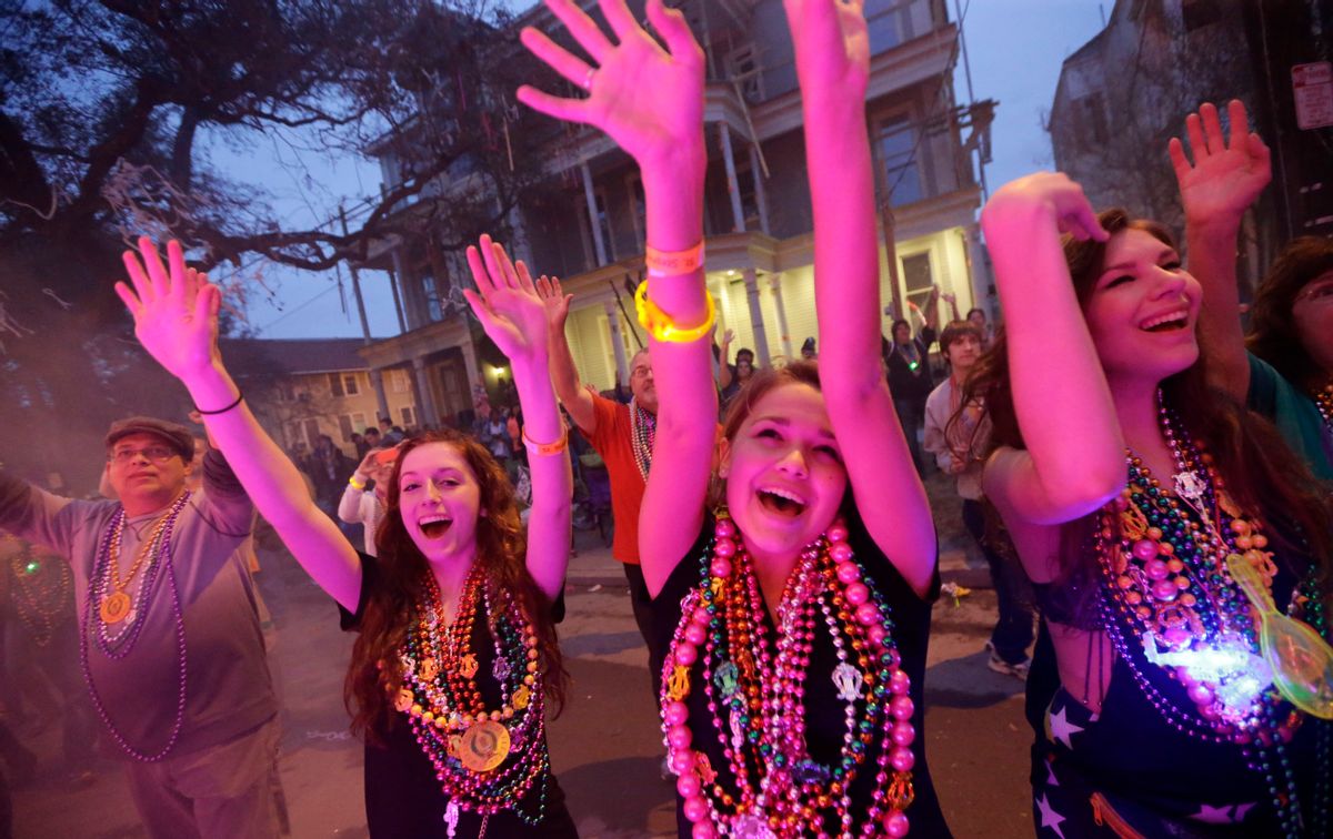 Parade-goers vie for beads and trinkets during the Krewe of Proteus Mardi Gras parade in New Orleans, Monday, Feb. 16, 2015. The day is known as Lundi Gras, the day before Mardi Gras. () (AP Photo/Gerald Herbert)