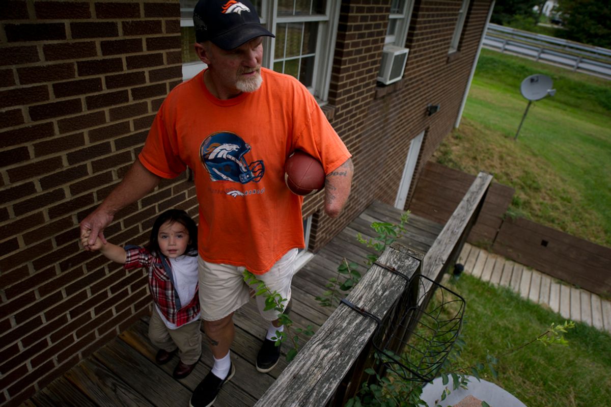 Despite the setbacks he’s faced with his injury and workers’ comp, Dennis Whedbee has tried to maintain an active life, waking early for yard sales, cooking homemade spaghetti sauce and throwing a football with his grandsons. Here, he walks his grandson Haven, 2, back inside their home in Homer City, Pennsylvania.(Jeff Swensen for ProPublica)    (Jeff Swensen For Propublica)