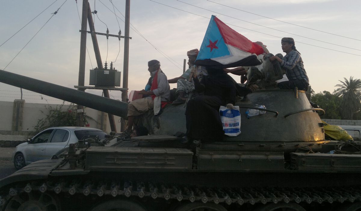 Militiamen loyal to President Abed Rabbo Mansour Hadi ride on a tank on a street in Aden, Yemen, Thursday, March 19, 2015. A woman on the tank holds a representation of the old South Yemen flag that was used when southern Yemen was an independent state until 1990. Forces loyal to Yemen's former President Ali Abdullah Saleh stormed the international airport in the southern port city of Aden on Thursday, triggering an intense, hours-long gunbattle with the forces of the current President Hadi that intensified a monthslong struggle for power threatening to fragment the nation. (AP Photo/Hamza Hendawi) (AP)