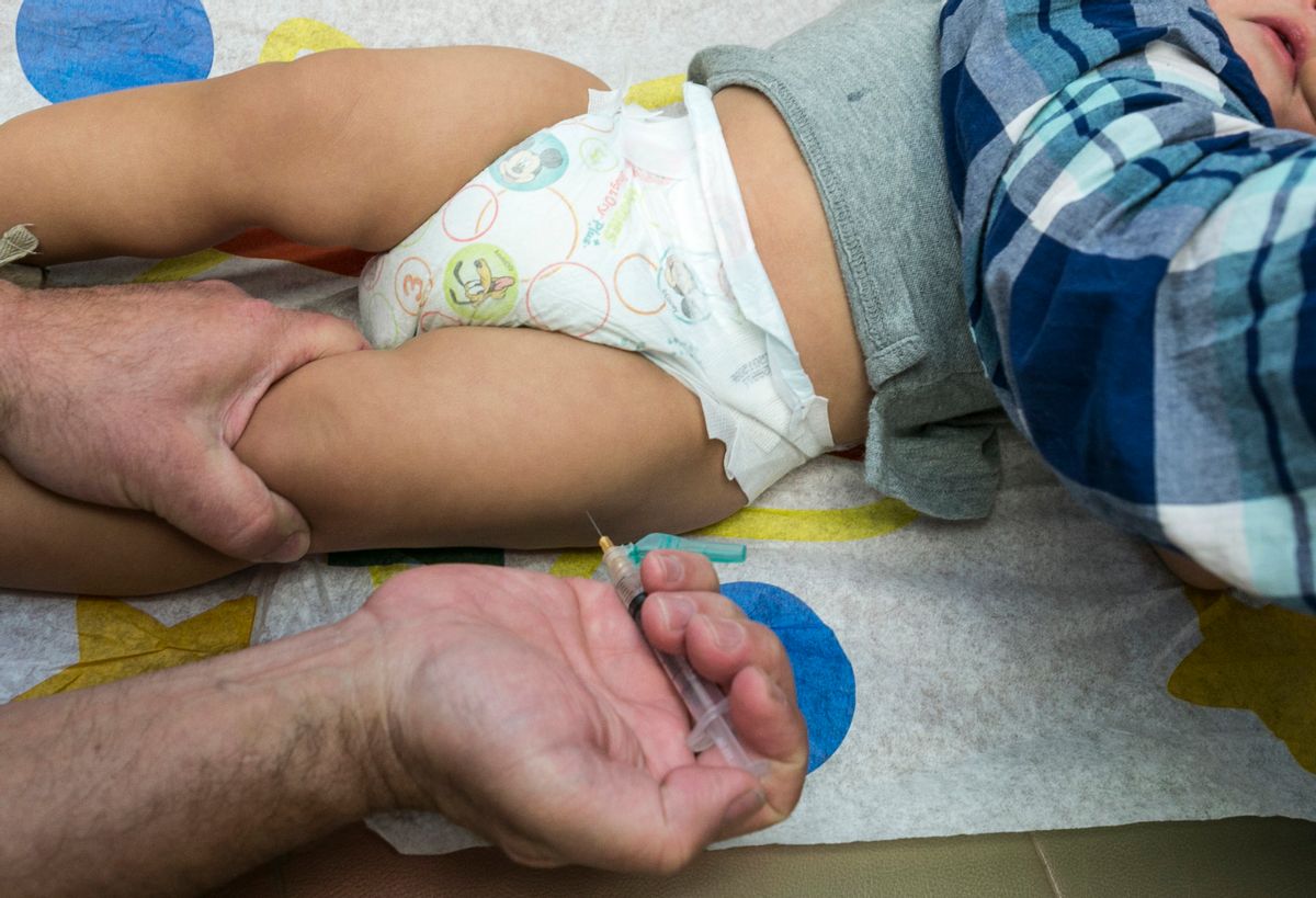 FILE - In this Jan. 29, 2015 file photo, a pediatrician uses a syringe to vaccinate a 1-year-old with the measles-mumps-rubella (MMR) vaccine in Northridge, Calif.  (AP Photo/Damian Dovarganes, File)