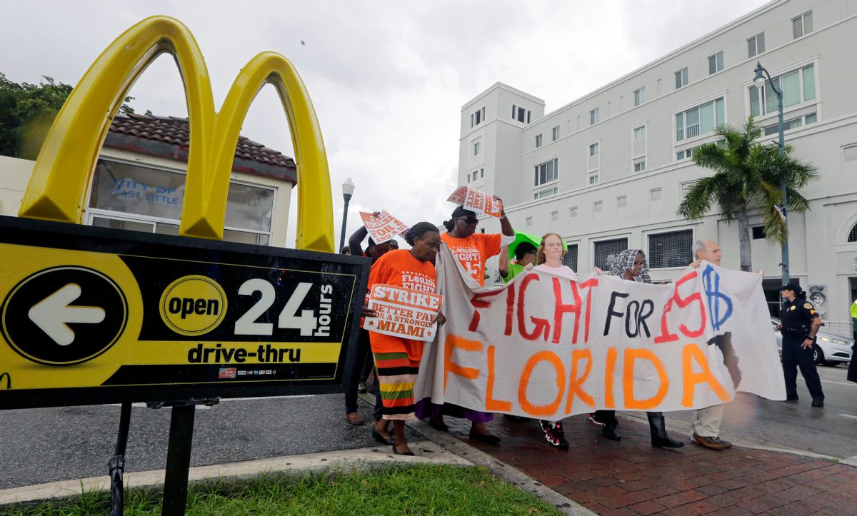 FILE - In this Dec. 4, 2014 file photo, people protest for higher wages outside a McDonald's restaurant in the Little Havana area of Miami. McDonalds workers in 19 cities have filed complaints over burns from hot grills and fryers and other workplace hazards, according to labor organizers. The complaints are the latest move in an ongoing campaign to win pay of $15 an hour and unionization for fast-food workers, in part by publicly pressuring McDonalds to come to the bargaining table. (AP/Alan Diaz)