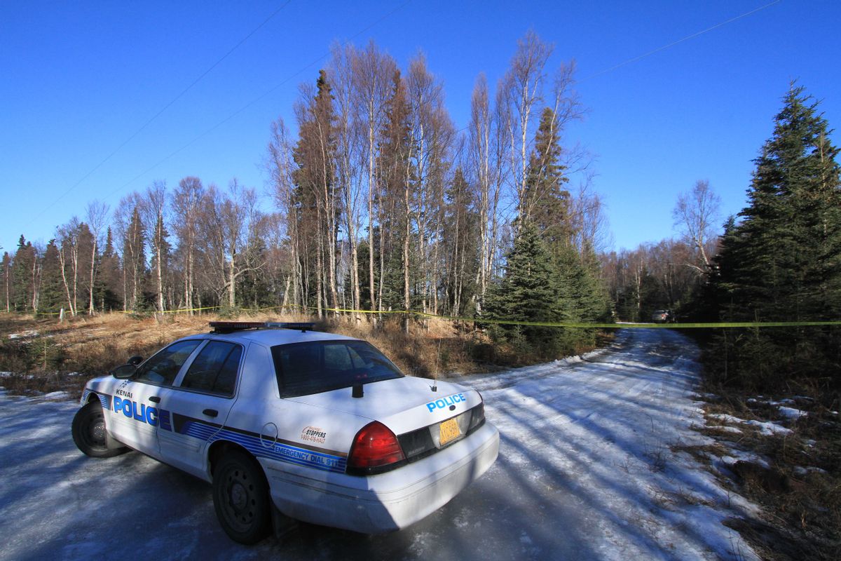 A Kenai Police Department patrol car parked on Alpine Avenue blocks an unnamed trail on Monday, March 23, 2015, in Kenai, Alaska. Human remains of four people were found Saturday night about 15 yards off the trail and Kenai police say evidence indicates they were members of family that has been missing since May.  (AP Photo/Dan Joling) (AP)
