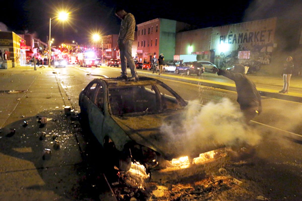 A rioter stands atop a burning car in Baltimore, Maryland April 27, 2015.           (Reuters/Jim Bourg)