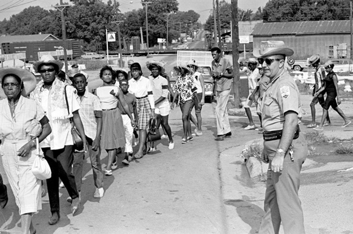 Neshoba County Deputy Sheriff Cecil Price watches marchers as they pass through Philadelphia, Miss., during a memorial for three slain civil rights workers, June 21, 1965.        (AP/Jack Thornell)