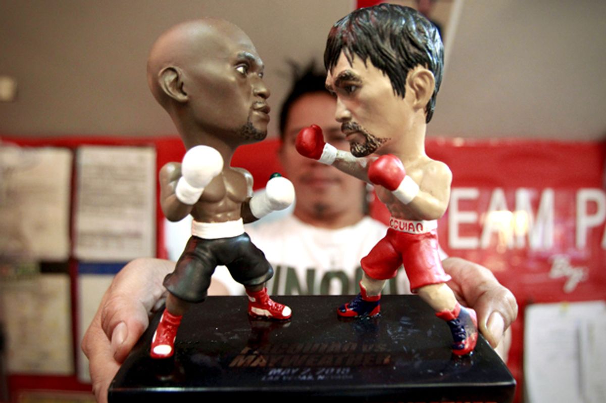 A store employee holds up miniature figurines of Manny Pacquiao and Floyd Mayweather Jr., Manila, April 23, 2015.       (Reuters/Romeo Ranoco)