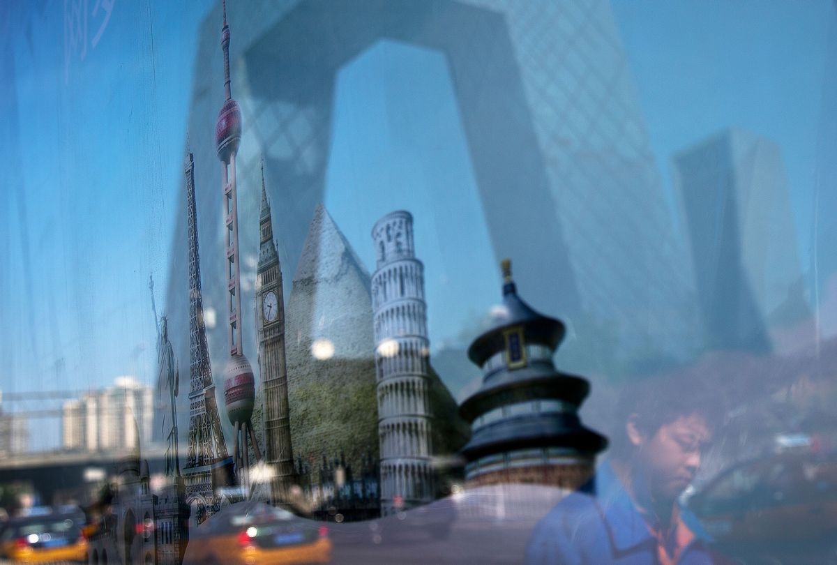 A man and the building of China Central Television (CCTV) headquarters is reflected on an advertisement billboard shows various countries' scenic places on display at the Central Business District of Beijing, China Wednesday, May 20, 2015. If the U.S. doesn't write the rules of international trade, President Barack Obama warns, China will. In fact, China is already helping write those rules, and in some ways has jumped ahead of the game. (AP Photo/Andy Wong) (Andy Wong)