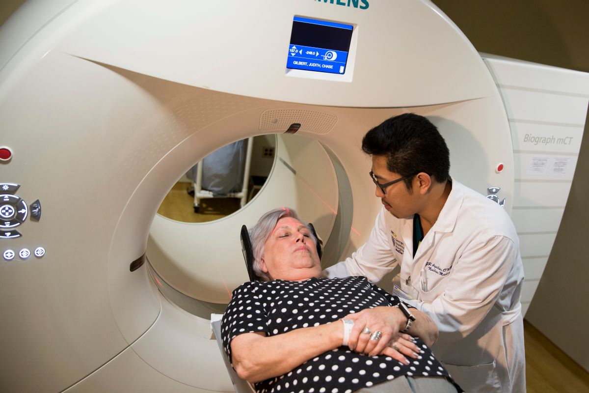 In this photo taken May 19, 2015, Judith Chase Gilbert, of Arlington, Va., is loaded into a PET scanner by Nuclear Medicine Technologist J.R. Aguilar at Georgetown University Hospital in Washington. Gilbert shows no signs of memory problems but volunteered for a new kind of scan as part of a study peeking into healthy brains to check for clues about Alzheimer's disease.  (AP Photo/Evan Vucci) (AP)