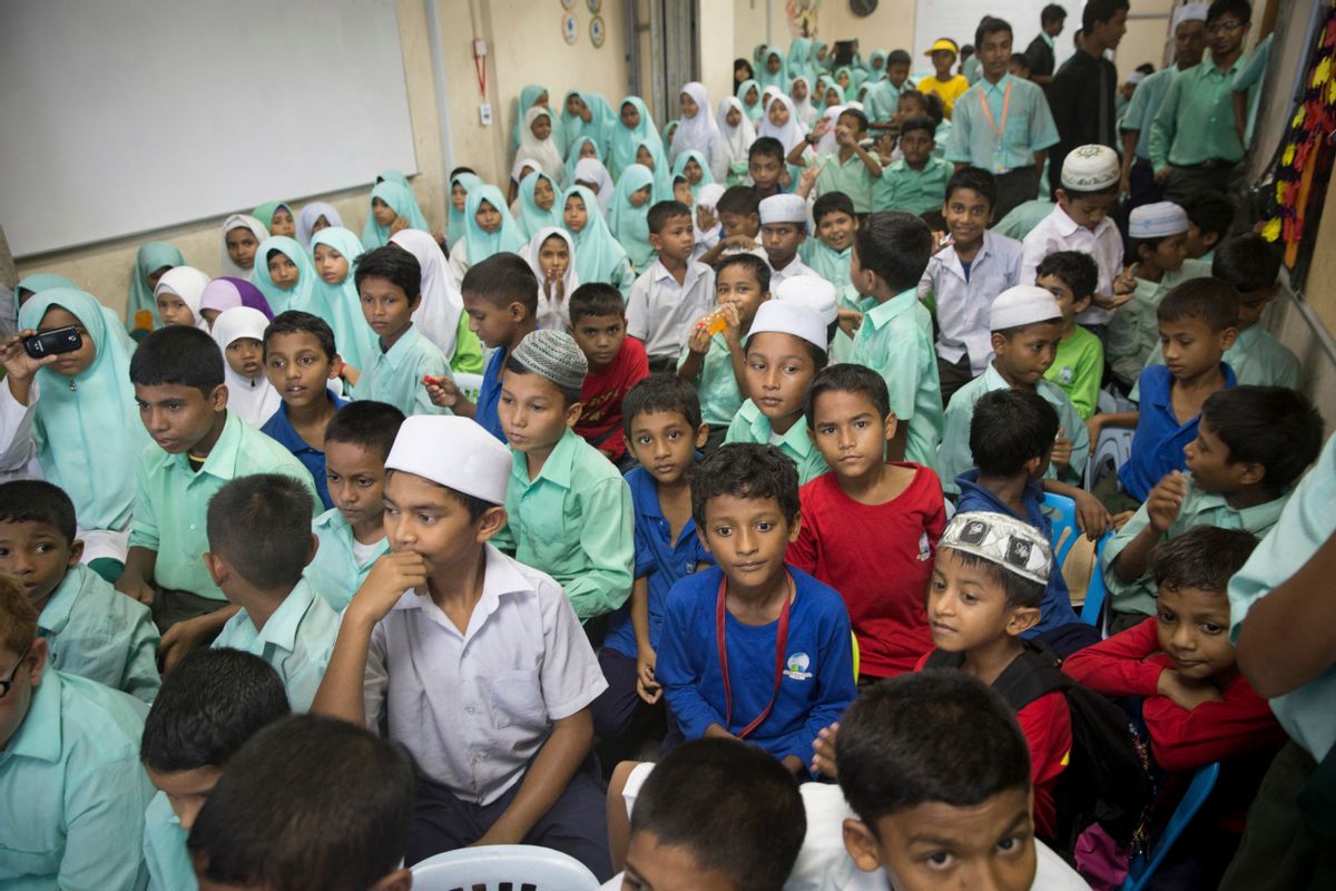 In this May 21, 2015  photo, Rohingya school kids watch teacher day celebrations outside their classroom at a Rohingya Education Center in Klang, Malaysia. With more work opportunities than Indonesia and a more Muslim-friendly environment than Thailand, Malaysia has long been the destination of choice for Rohingya Muslims fleeing persecution in Myanmar.  (AP Photo/Vincent Thian) (AP)