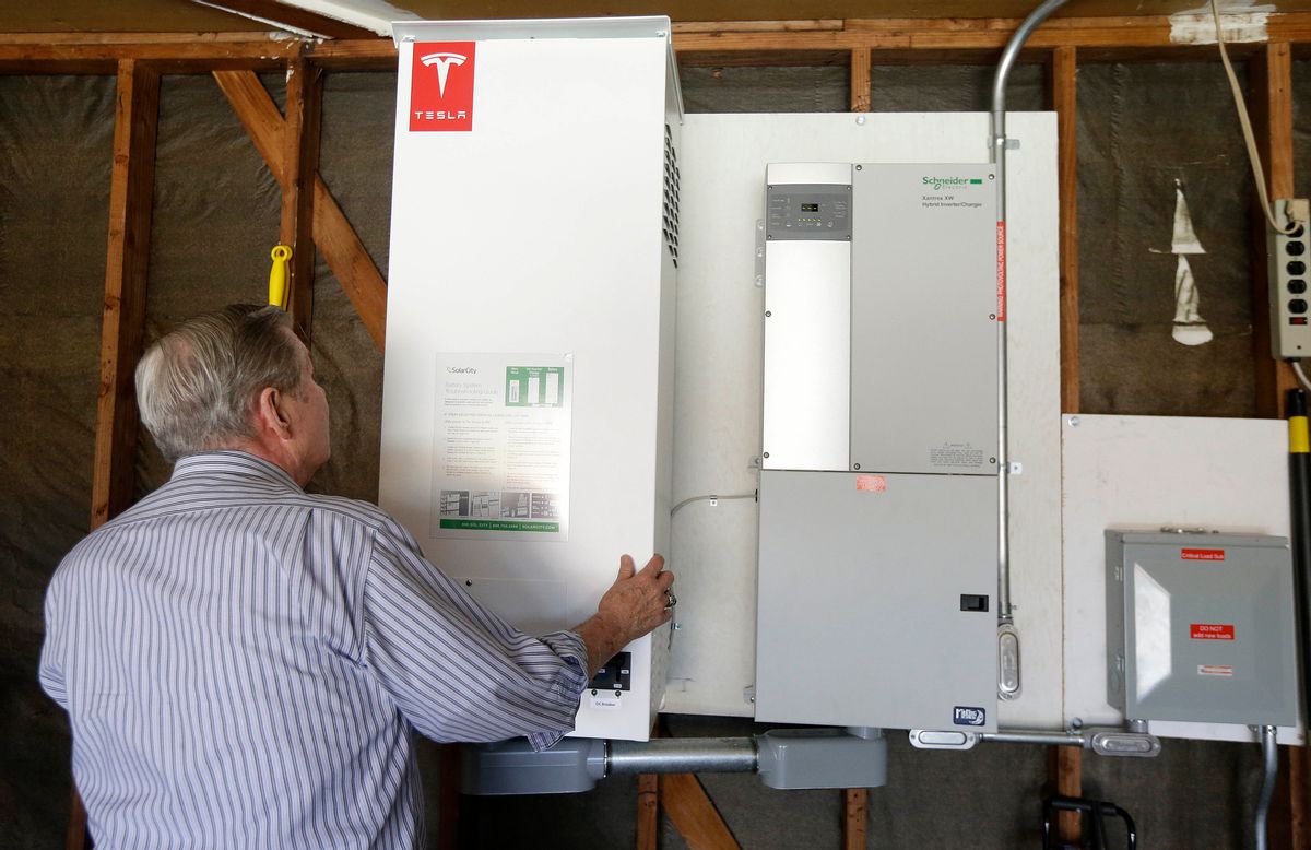 In this April 20, 2015 photo, David Cunnigham shows a prototype Tesla battery system that powers his Foster City, Calif. home.  (AP Photo/Jeff Chiu)