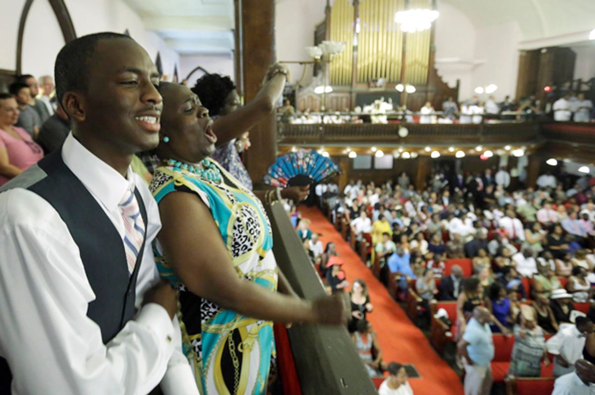 Parishioners Shakur Francis, left, and Karen Watson-Fleming sing at the Emanuel A.M.E. Church Sunday, June 21, 2015, in Charleston, S.C.    (AP/David Goldman)
