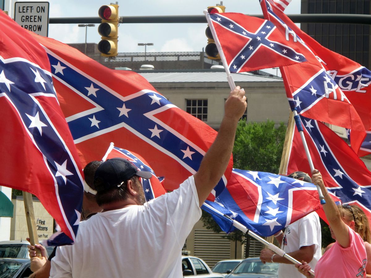 Supporters of keeping the Confederate battle flag flying at a Confederate monument at the South Carolina Statehouse wave flags during a rally in front of the statehouse in Columbia, S.C., on Saturday, June 27, 2015. Gov. Nikki Haley and a number of  other state leaders have called for the removal of the flag following the shooting deaths of nine black parishioners in a church in Charleston last week.  (AP Photo/Bruce Smith) (AP)