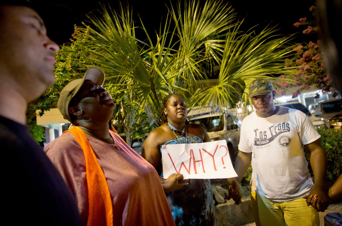 Surreace Cox, of North Charleston, S.C., holds a sign during a prayer vigil down the street from the Emanuel AME Church early Thursday, June 18, 2015, following a shooting Wednesday night in Charleston, S.C. (AP Photo/David Goldman) (AP)