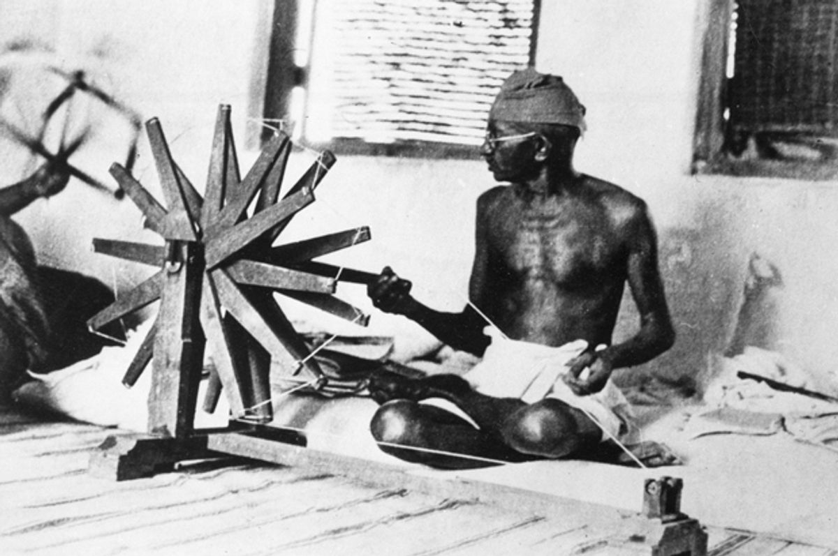 Mahatma Gandhi sits cross-legged and spins cotton in Ahmadabad, India, circa 1931.     (AP)