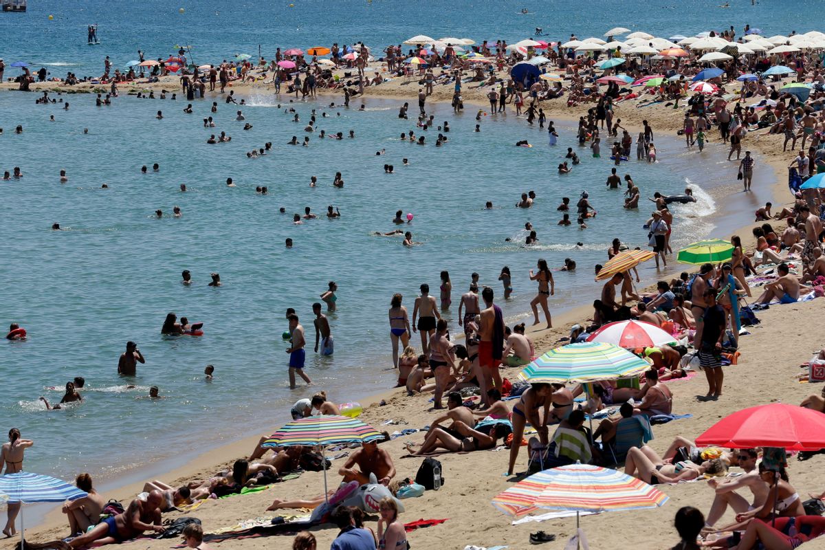 People sunbathe on a beach in Barcelona, Spain, Sunday, June 28, 2015.  (AP Photo/Manu Fernandez)